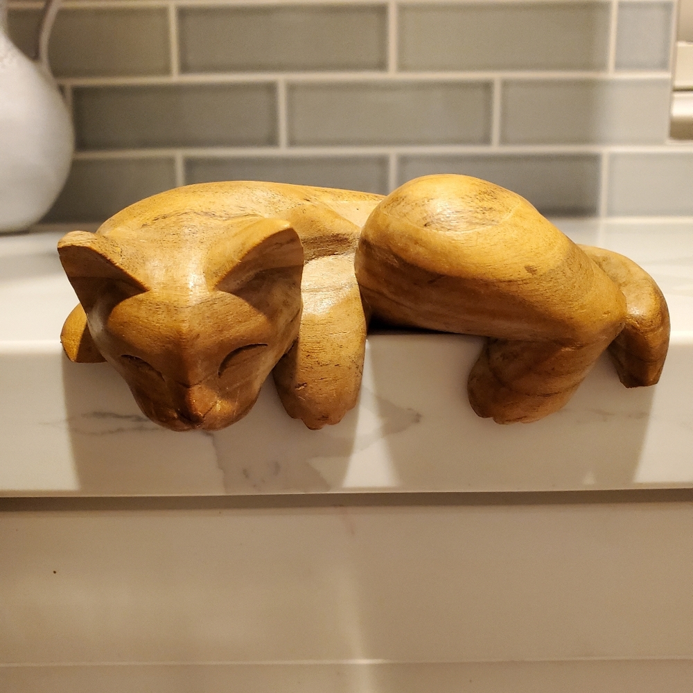 Hand carved napping cat, missing part of ear and leg and tail